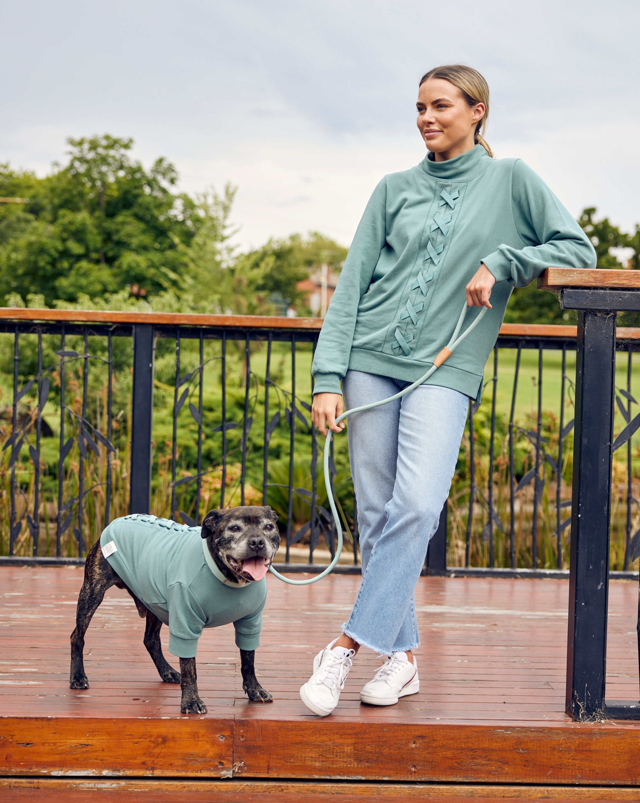 A girl and her staffy wearing green match your dog sweats.