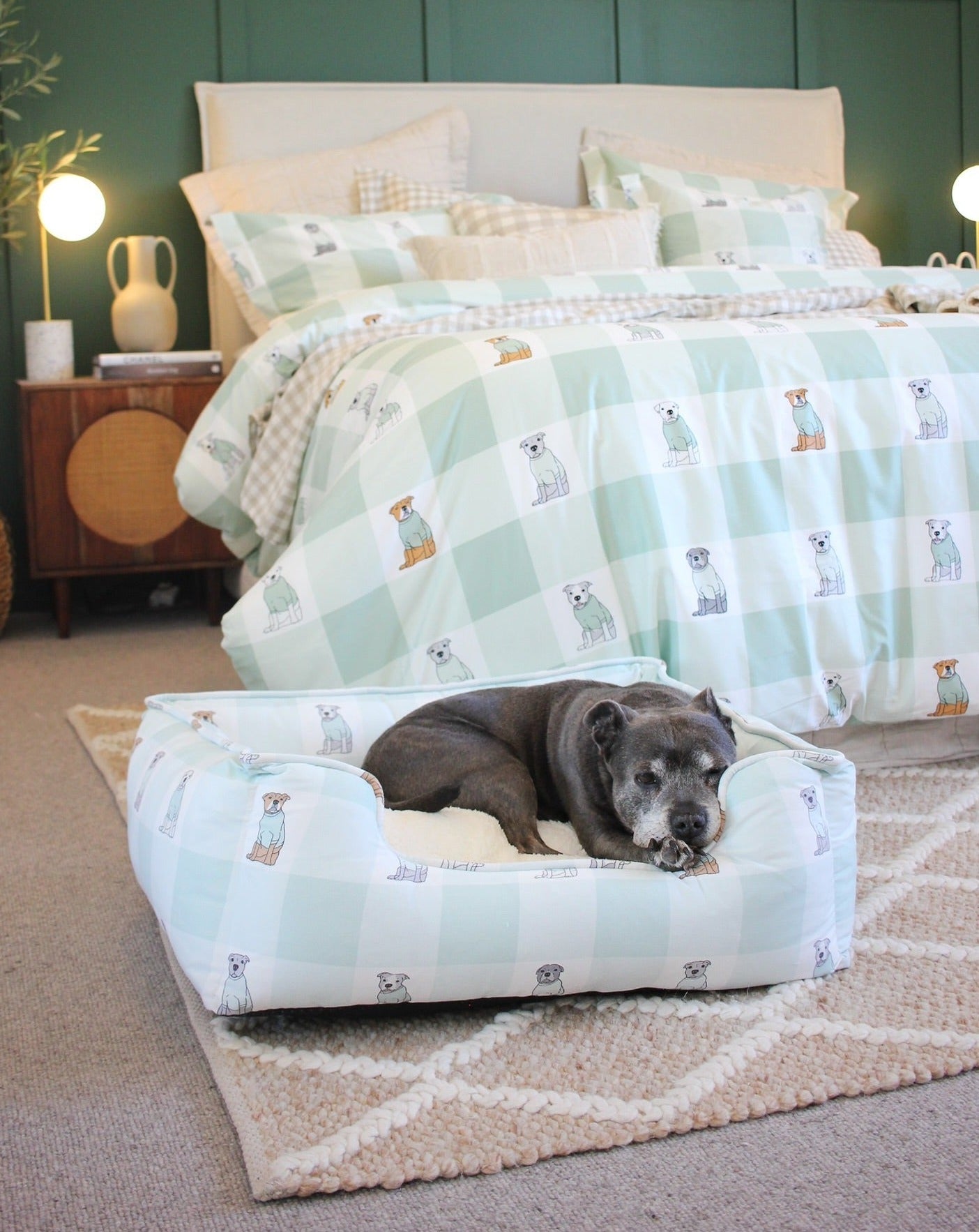 A staffy sleeping in a Darren and Phillip removable cover dog bed.